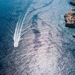 Boat sealing in Atlantic ocean view from above. Aerial view of Atlantic ocean coast