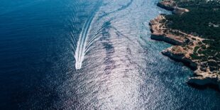 Boat sealing in Atlantic ocean view from above. Aerial view of Atlantic ocean coast